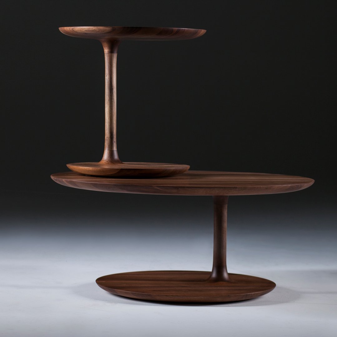 Two-tiered wood serving tray in rich walnut finish, featuring smooth curves and a sleek, modern design.