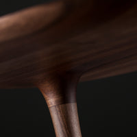 Close-up of a stylish wooden table showcasing rich walnut tones and smooth, natural grain patterns.