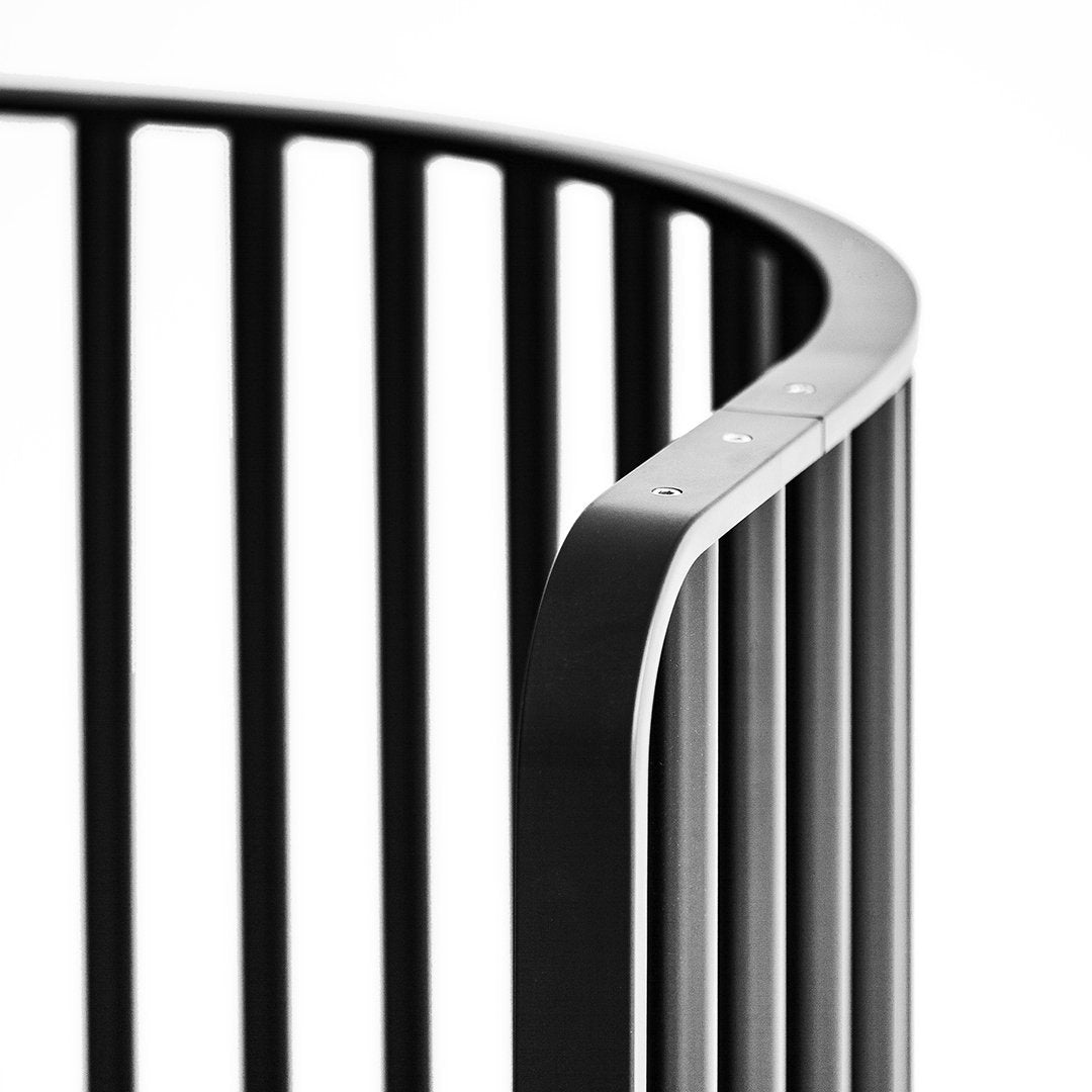 Black curved crib with vertical slats, featuring a sleek modern design and smooth, rounded edges.