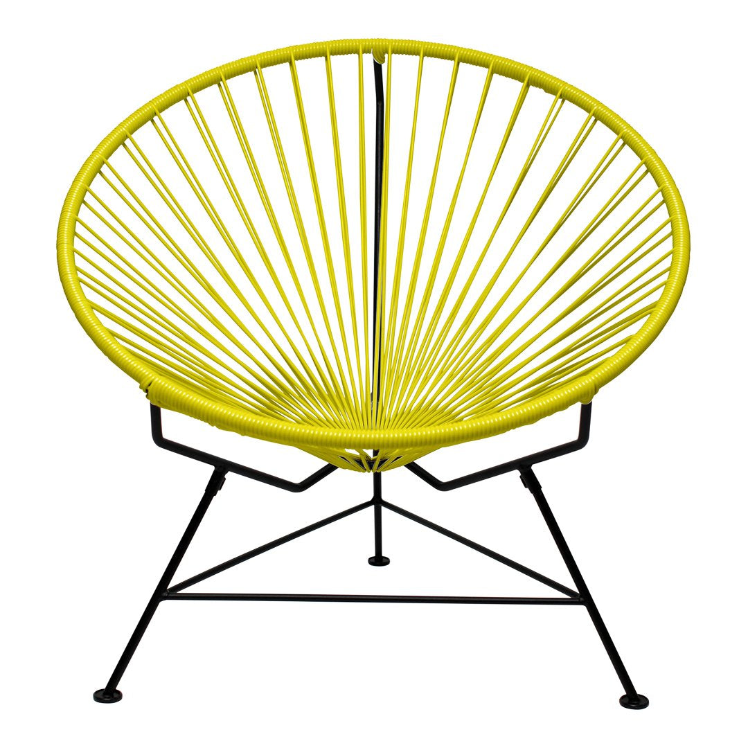 Yellow Acapulco chair with a sunburst pattern, featuring a sleek black metal frame. Perfect for vibrant decor.