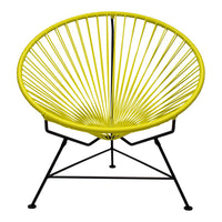 Yellow Acapulco chair with a sunburst pattern, featuring a sleek black metal frame. Perfect for vibrant decor.