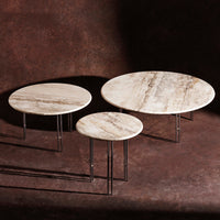 "Set of three round coffee tables with a cream marble pattern and sleek metal legs, against a dark background."