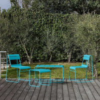 Turquoise outdoor furniture set featuring two chairs and a table, set against a lush green backdrop.