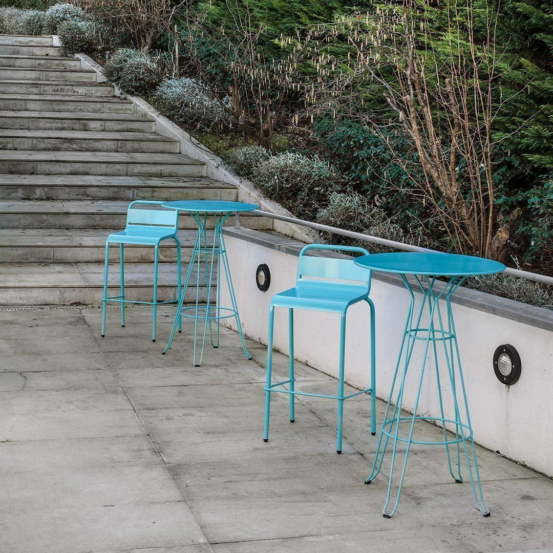 Turquoise outdoor bar stools with sleek metal design, featuring minimalist patterns on a contemporary patio setting.