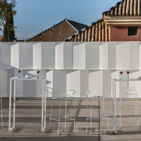 "Modern white outdoor bar furniture against a textured white wall, perfect for stylish gatherings."
