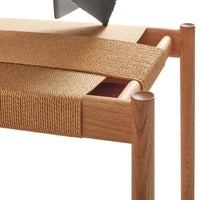 Natural wood table with beige woven pattern and smooth wooden edges. Elegant and minimalist design.