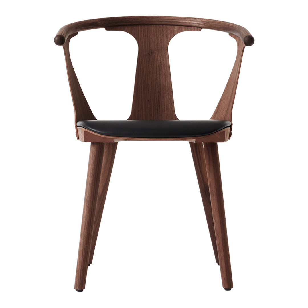 Stylish walnut chair with a smooth black seat and minimalist design, featuring clean lines and elegant curves.