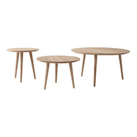 Set of three round wooden tables in natural oak finish with simple, sleek legs. Perfect for modern decor.