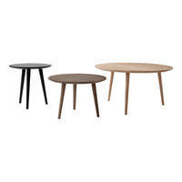 Set of three round wooden tables in black, brown, and natural wood finishes, featuring sleek, simple design.