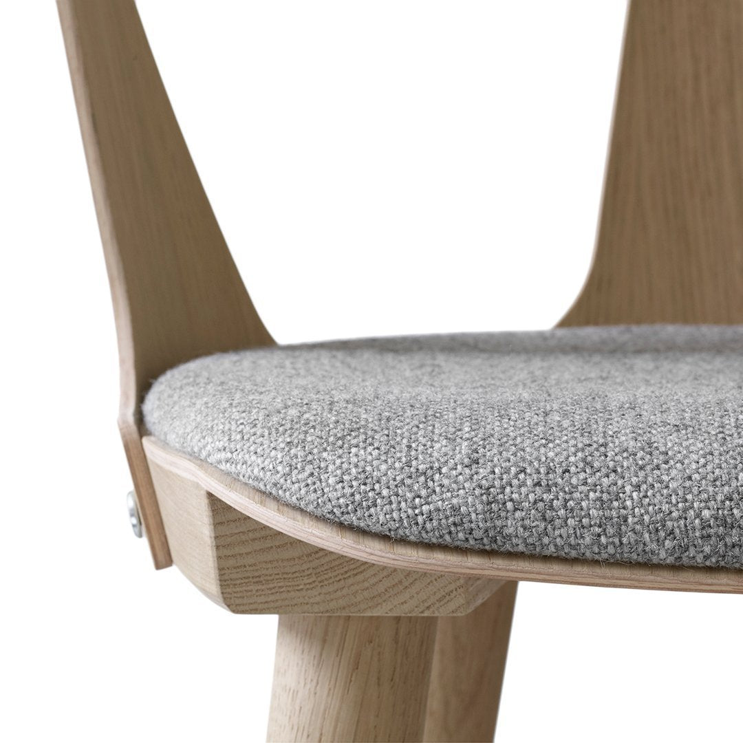 Light wood chair featuring a textured gray fabric seat, highlighting a minimalist and modern design.