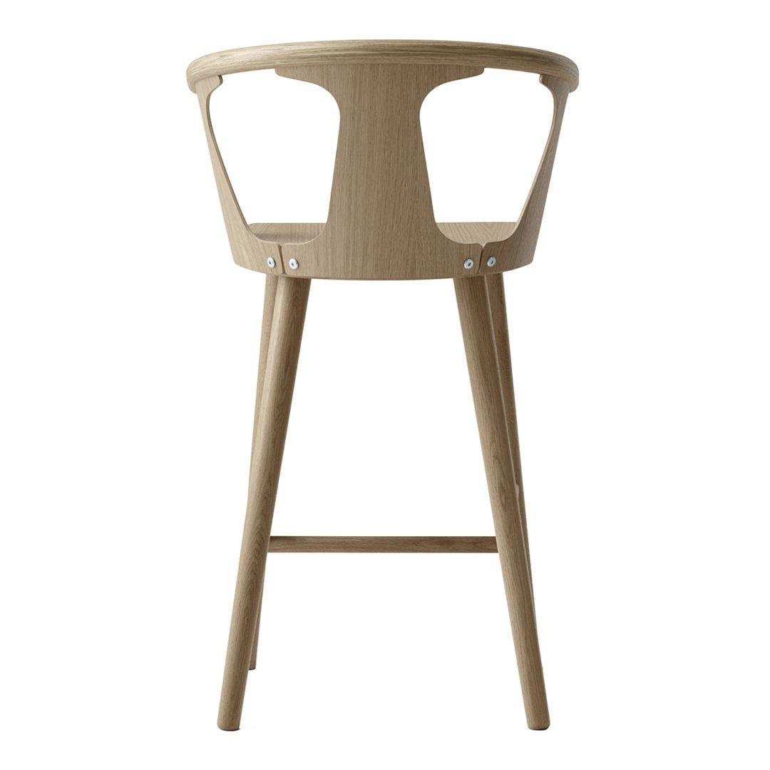 Natural wood bar stool with a light tan finish and minimalist design. Smooth curves and clean lines.