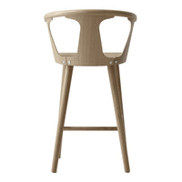 Natural wood bar stool with a light tan finish and minimalist design. Smooth curves and clean lines.