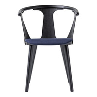 Black chair with a smooth textured finish and a deep blue fabric seat, featuring sleek, modern lines.