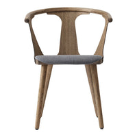 "Natural wood chair with a smooth gray upholstered seat and elegant curvy backrest."