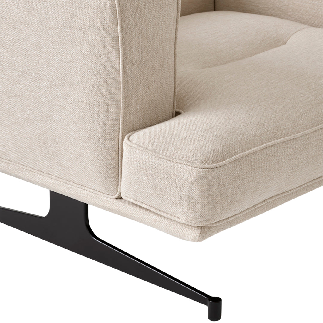 Beige upholstered chair with a sleek black metal base, featuring a smooth, textured fabric pattern.