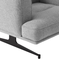 Gray upholstered chair with a tufted design and sleek black metal base. Sophisticated and modern aesthetic.