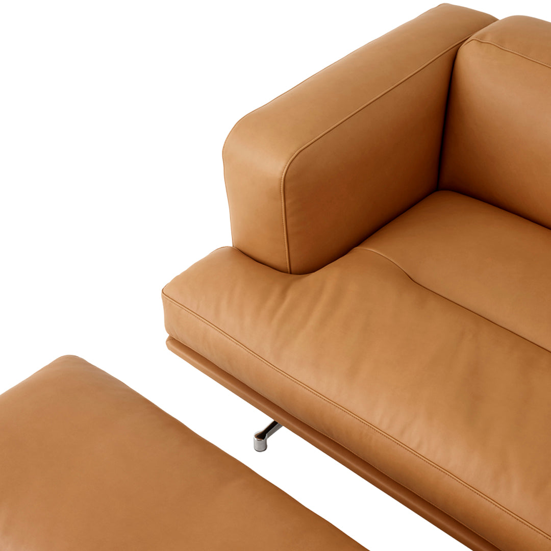 Tan leather sofa with smooth texture and minimalist design, featuring a matching ottoman. Perfect for modern interiors.