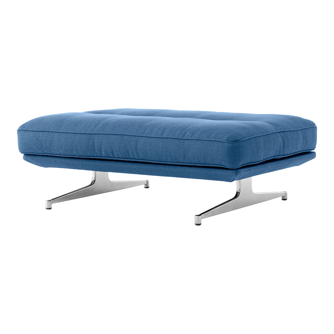 Modern blue upholstered ottoman with sleek chrome legs, featuring a subtle quilted pattern for added texture.