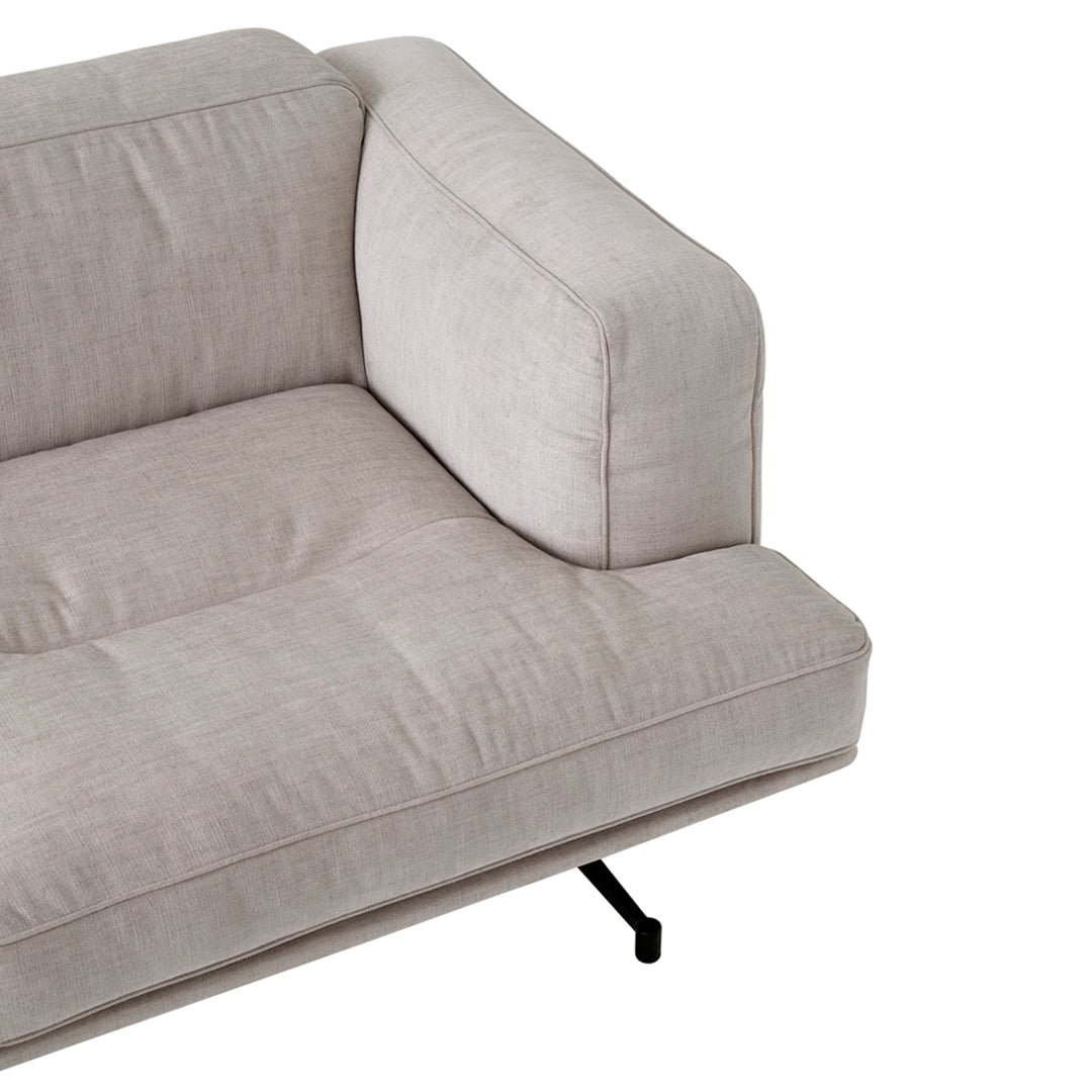 Light beige tufted fabric sofa with a sleek black metal frame, creating a modern and minimalistic aesthetic.