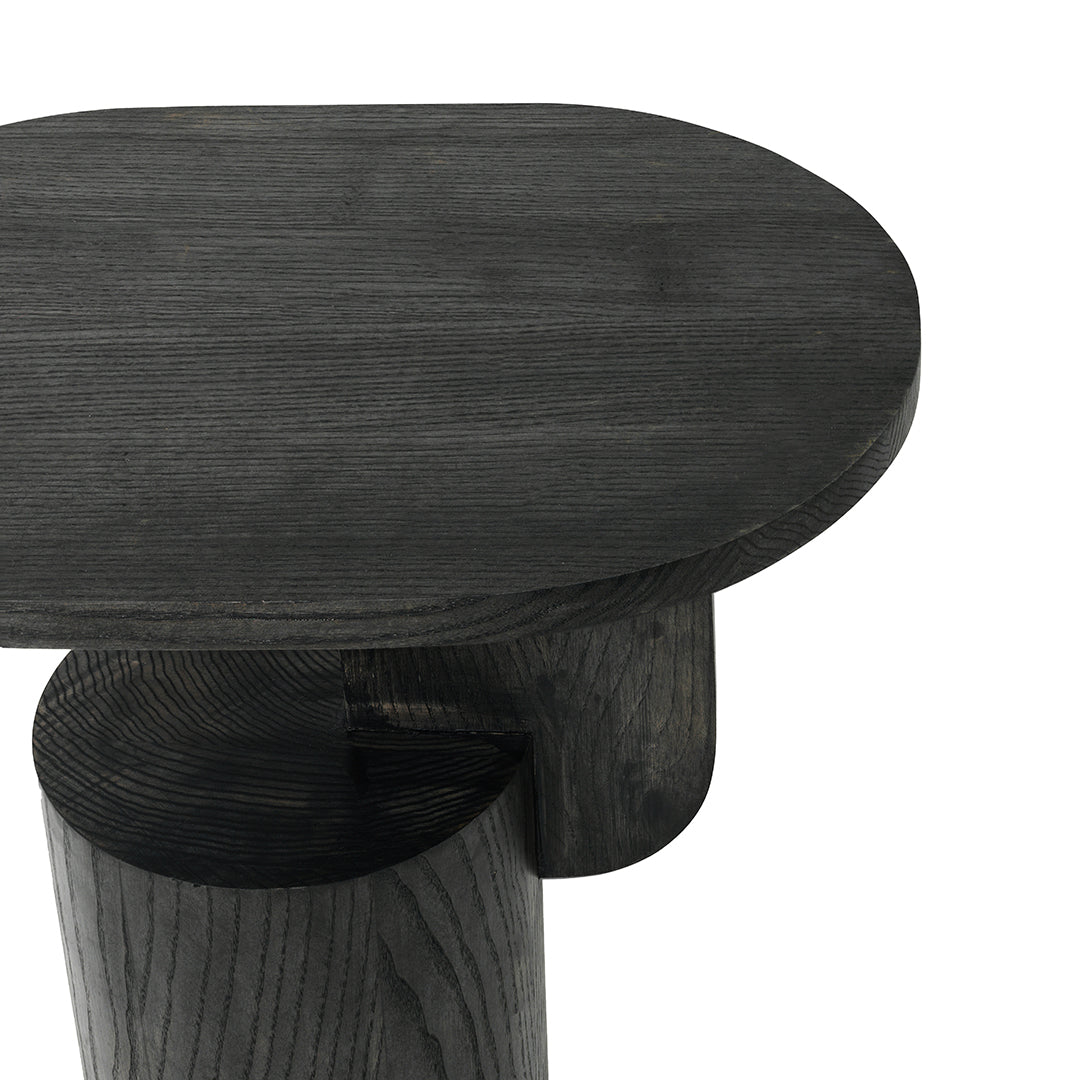 Dark charcoal wood table with a smooth oval top and rounded base, showcasing a modern minimalist design.