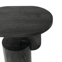 Dark charcoal wood table with a smooth oval top and rounded base, showcasing a modern minimalist design.