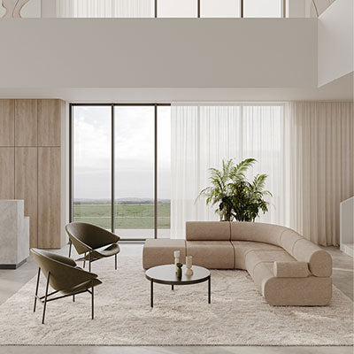 "Contemporary beige sofa with green accent chairs on a textured cream rug, bright airy space with large windows."