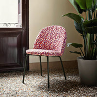 "Colorful patterned chair with pink, red, and white design on a sleek black metal base."
