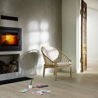 "Light wood chair with a plaid patterned cushion in a modern, minimalist living space."