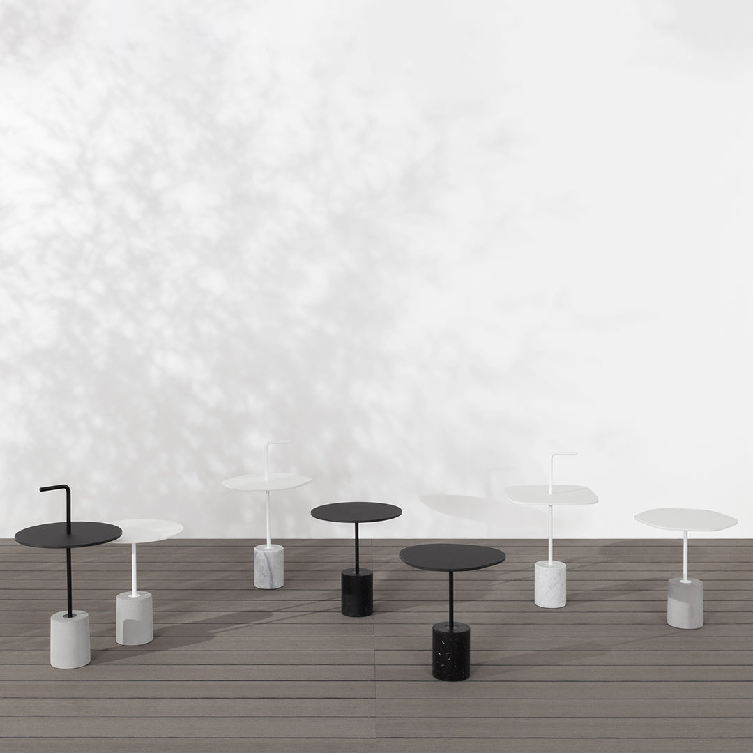Modern minimalist side tables in black and white, featuring sleek circular tops and cylindrical bases.