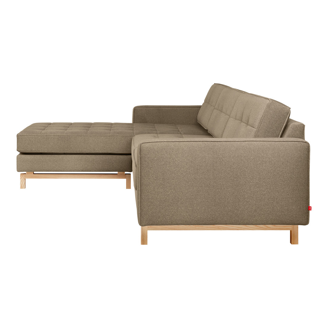 Stylish sectional sofa in soft brown fabric with tufted detailing and light wooden legs. Perfect for modern living spaces.
