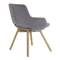 Soft gray velvet chair with curved back, featuring natural wood legs. Minimalist design for modern decor.