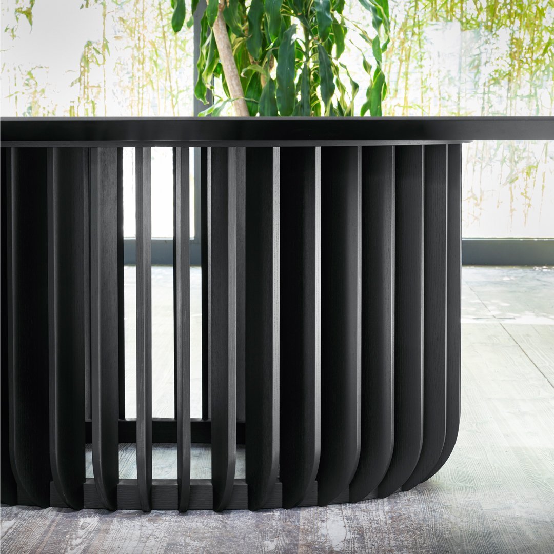 Black slatted table design with a sleek finish, showcasing modern lines and a contemporary aesthetic.