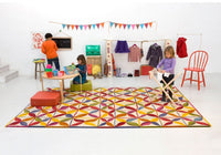 Colorful geometric rug featuring red, yellow, blue, and green patterns, perfect for kids' play areas.