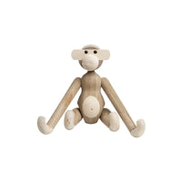 Wooden monkey figurine in natural wood tones with smooth, rounded features and minimalist design.