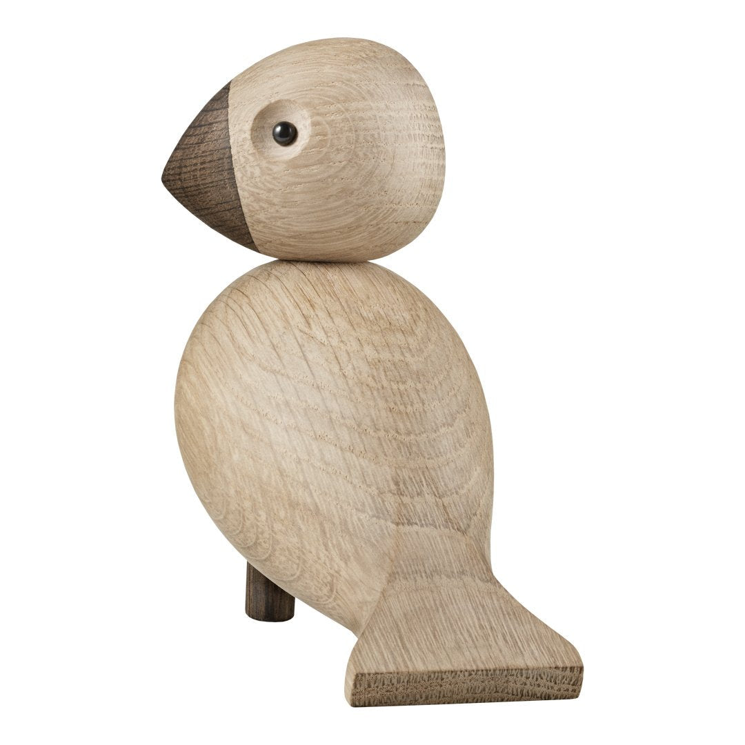 Wooden bird figurine in natural oak with a darker brown head, featuring smooth, rounded shapes and minimalist design.