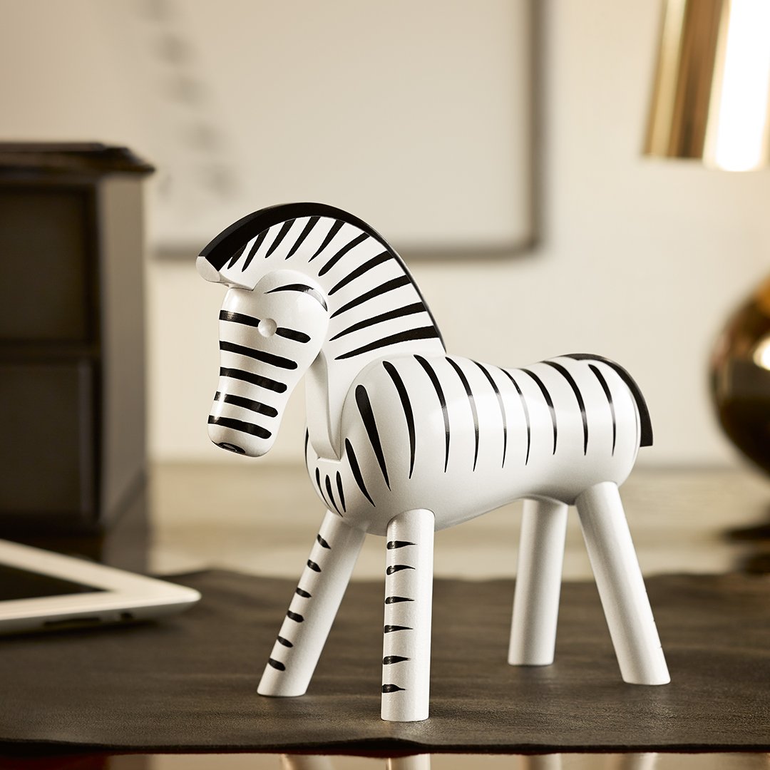 "Stylish zebra figurine in black and white stripes, perfect for modern decor accents."