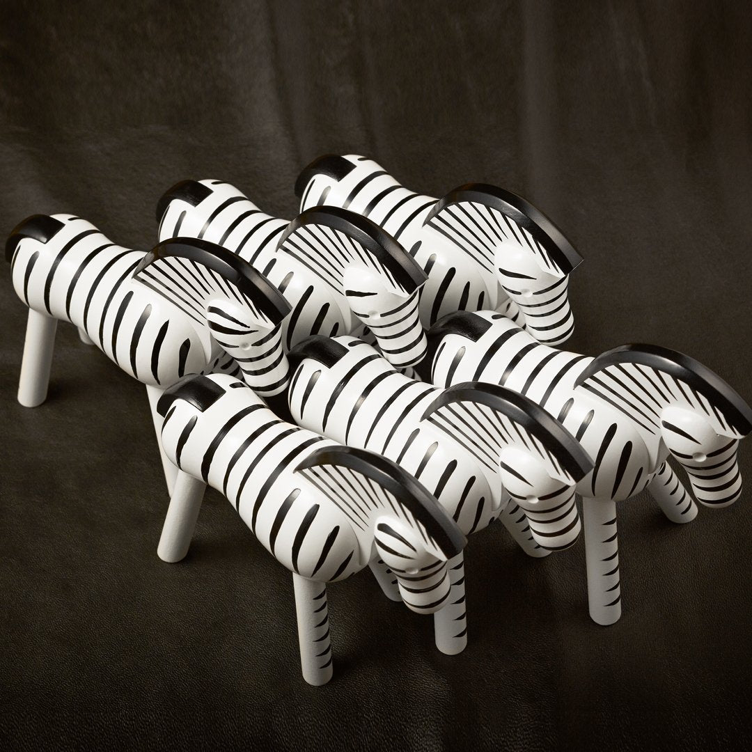Set of decorative zebras in black and white stripes against a dark background, showcasing bold contrasting patterns.