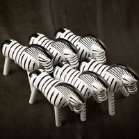 Set of decorative zebras in black and white stripes against a dark background, showcasing bold contrasting patterns.