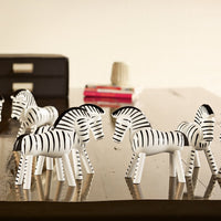 Black and white striped zebras arranged decoratively on a tabletop, showcasing a playful pattern.