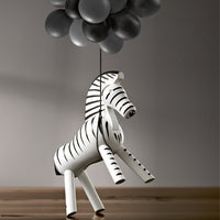 Black and white striped zebra toy with gray balloons, perfect for playful decor or children's rooms.
