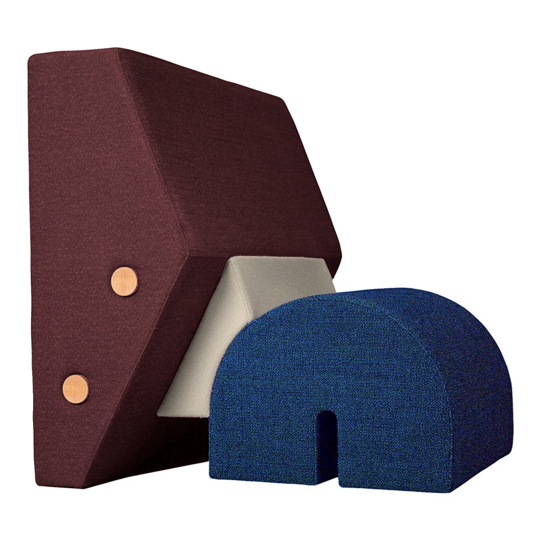 Burgundy and cream geometric design cushion with navy blue arch-shaped pillow, showcasing textured fabric patterns.