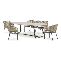 Oval dining table with a sleek gray top and six beige wicker chairs featuring black metal frames.