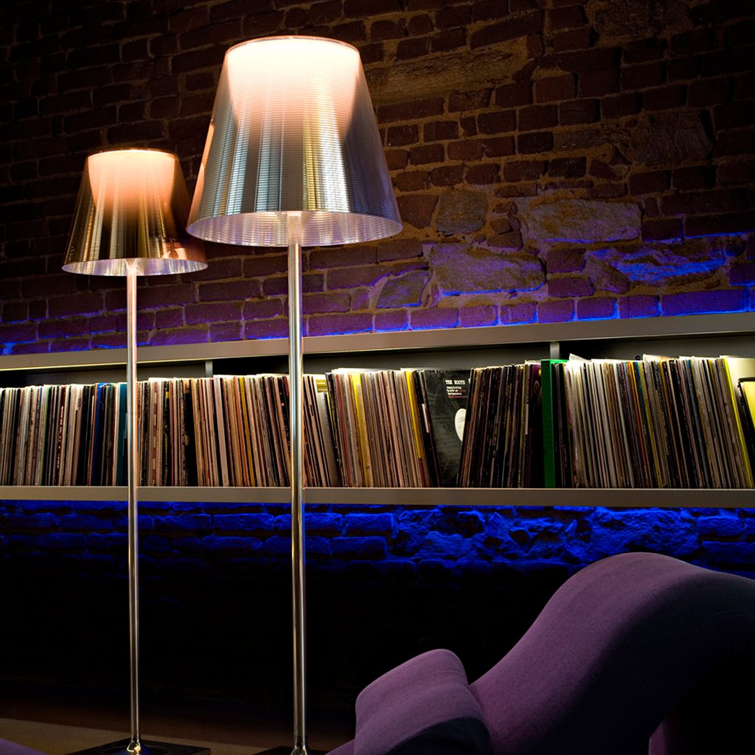 Metallic silver lamps with soft white shades, set against a backdrop of colorful vinyl records and blue ambient lighting.