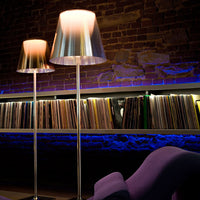 Metallic silver lamps with soft white shades, set against a backdrop of colorful vinyl records and blue ambient lighting.