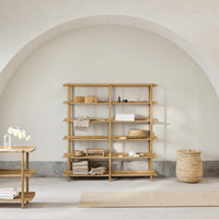 Natural wood shelving unit with a light, neutral wall and soft beige accents in a minimalistic setting.
