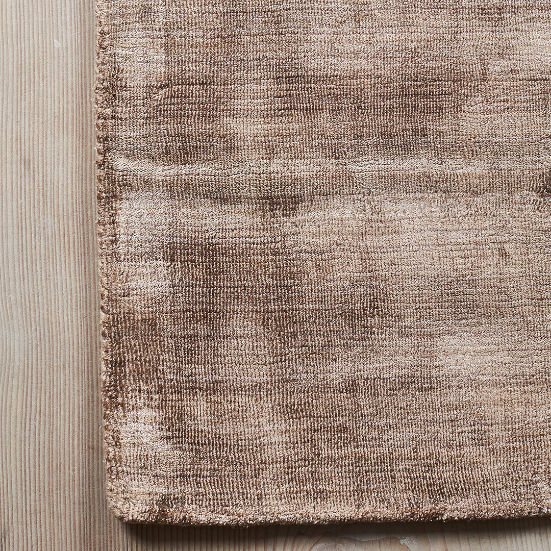 Soft brown woven rug with subtle texture and warm, earthy tones, ideal for cozy home decor.