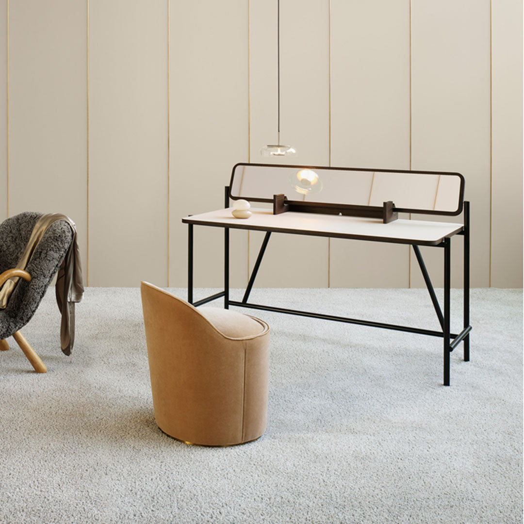 "Minimalist black and beige desk with a sleek design, complemented by a soft textured chair in warm tan hues."