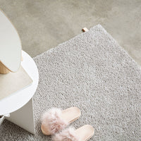 Soft gray shag rug with a plush texture, featuring light pink accents and subtle, cozy patterns.