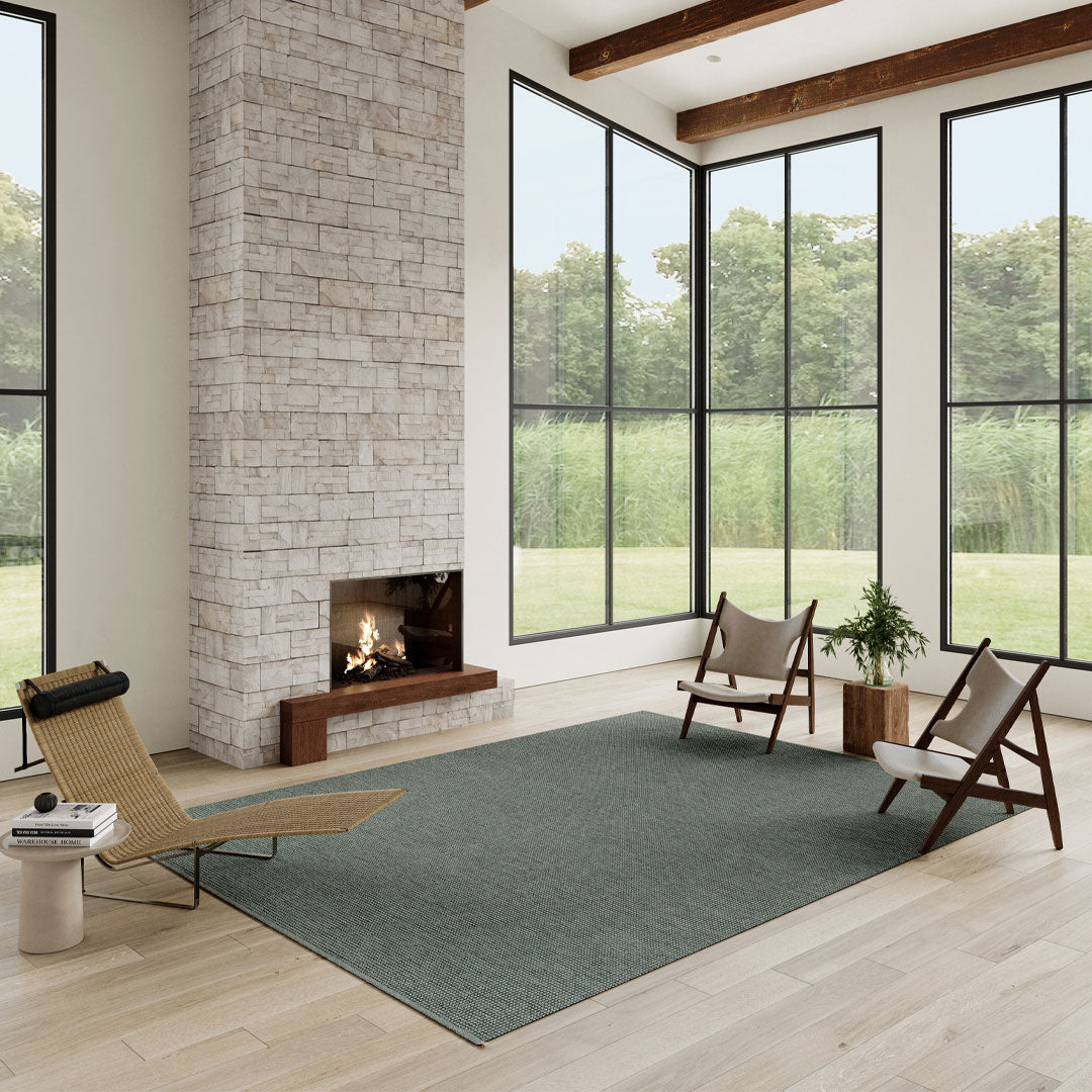 Textured green area rug in a modern living room with natural light, stone wall, and wooden accents.