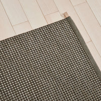 Dark brown mat with a textured pattern of small, light dots, perfect for adding warmth to any space.
